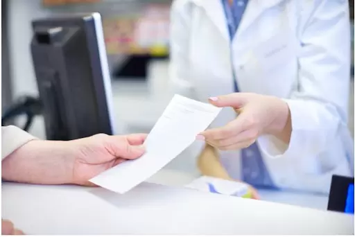 médica entrega receita a paciente para importação de medicamentos especiais