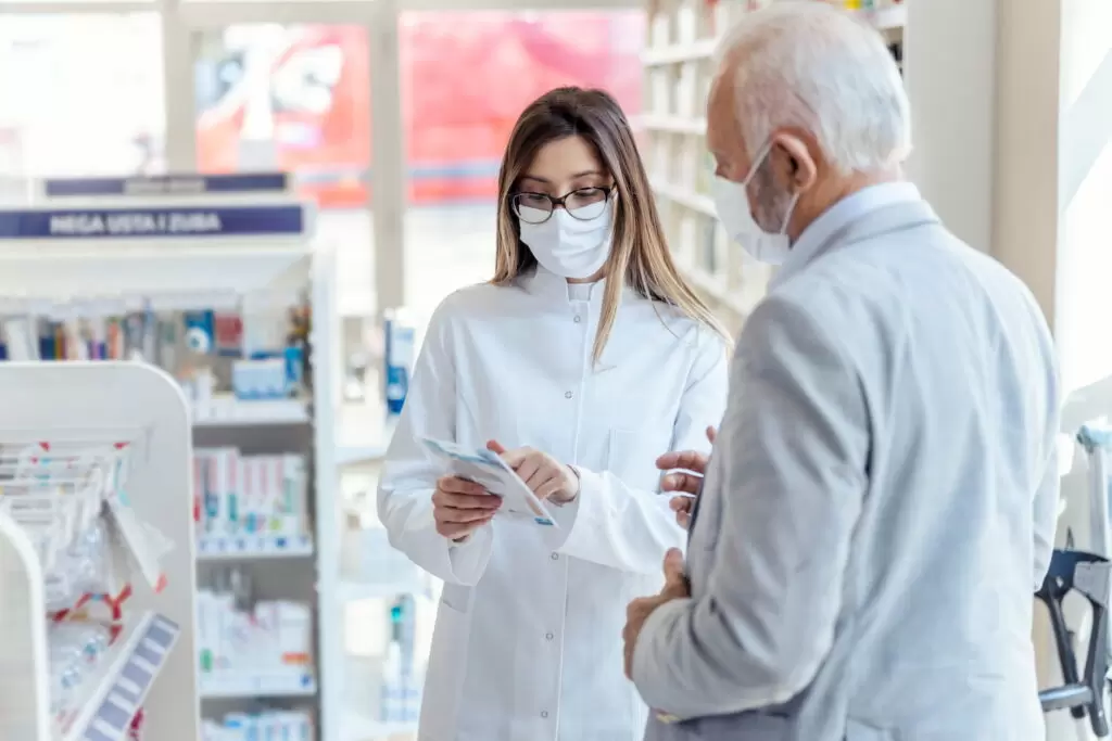 farmacêutica passando instruções sobre o medicamento adcetris (brentuximabe) para um senhor de idade