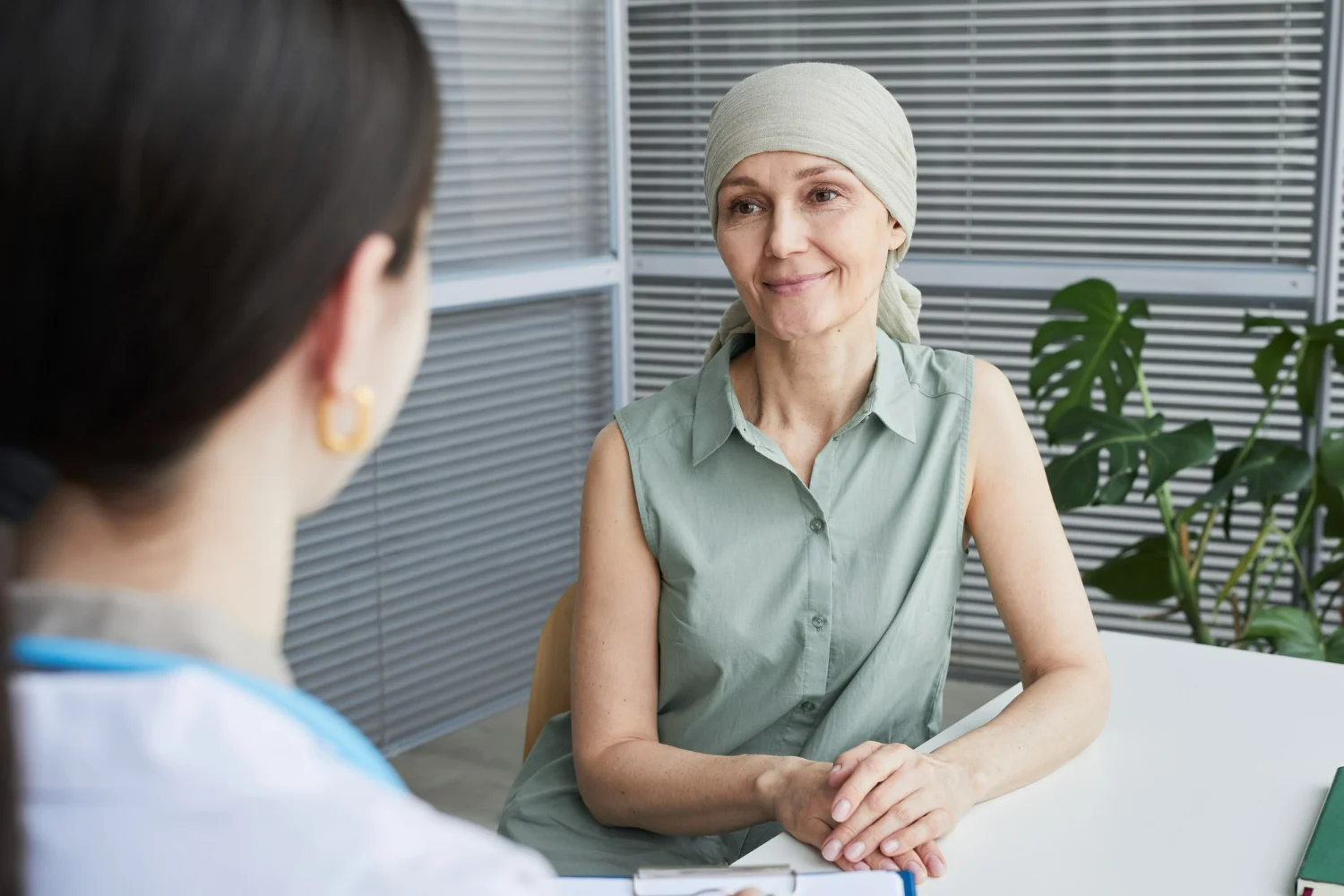 Paciente conversando com uma médica oncologista durante uma consulta