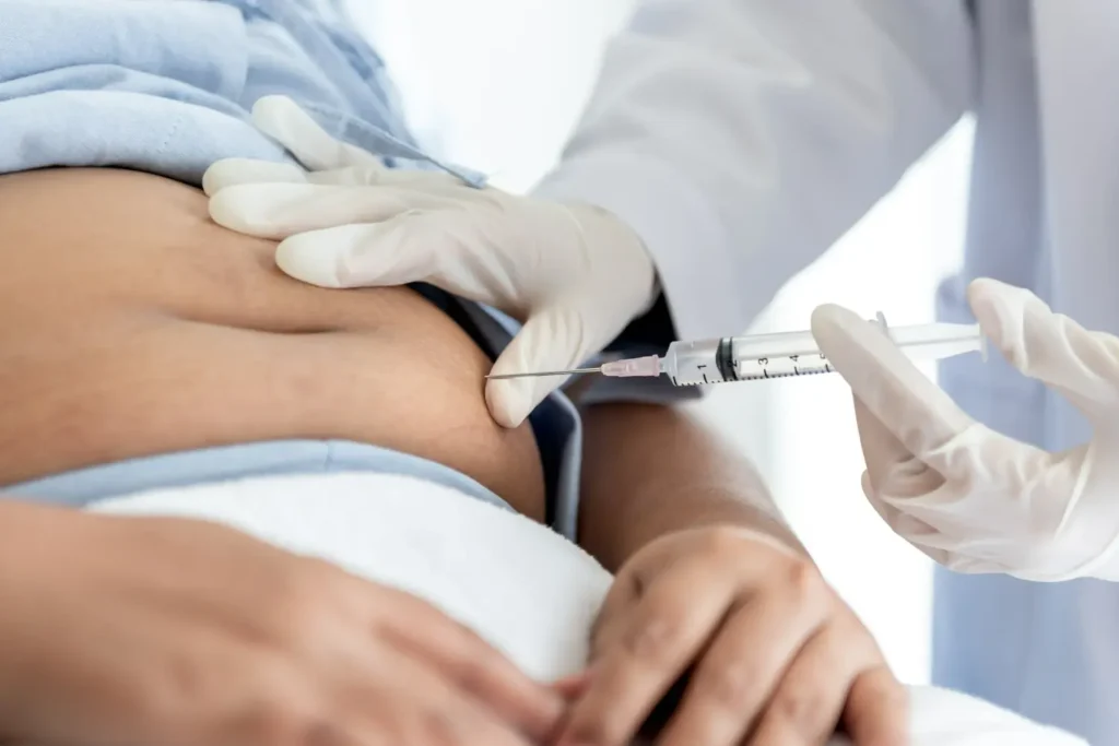 Médico aplicando seringa com medicamento Humira (Adalimumabe) no abdômen de paciente