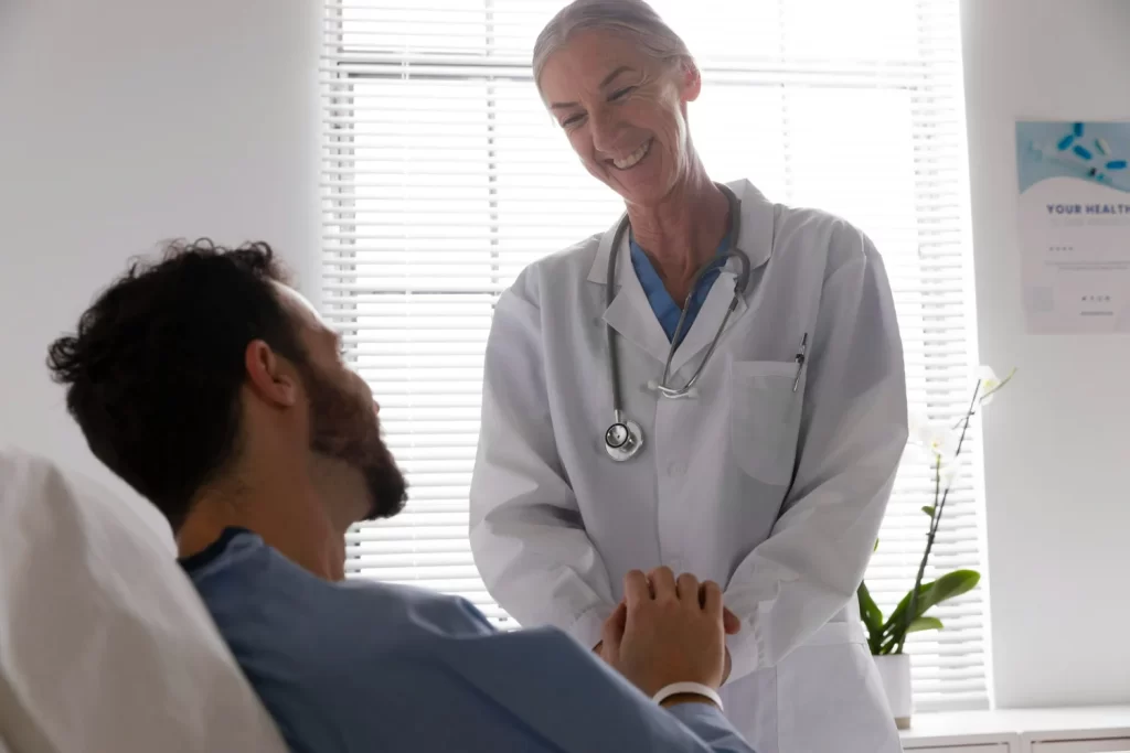 Homem com câncer de próstata conversando com a médica sobre o congelamento de sémen.