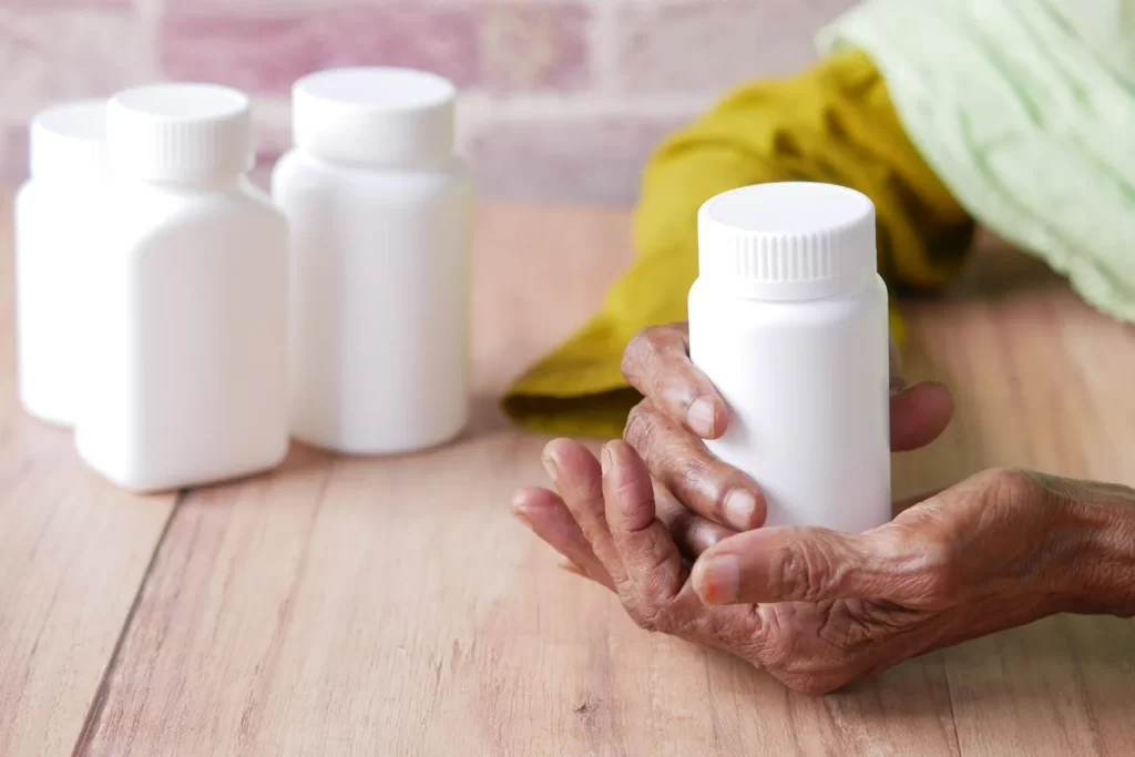 Imagem de duas mãos segurando frasco branco de medicamento ilustrando o Rydapt.