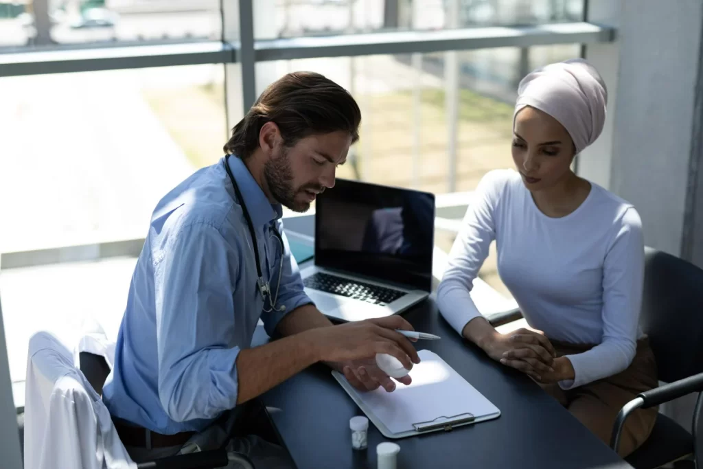 Médico orientando paciente enquanto explica para que serve asciminibe