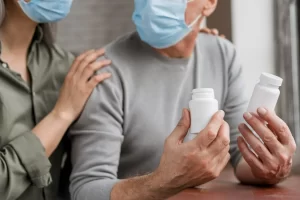 Paciente oncológico segura medicamento para terapia-alvo no câncer, ao lado de sua esposa