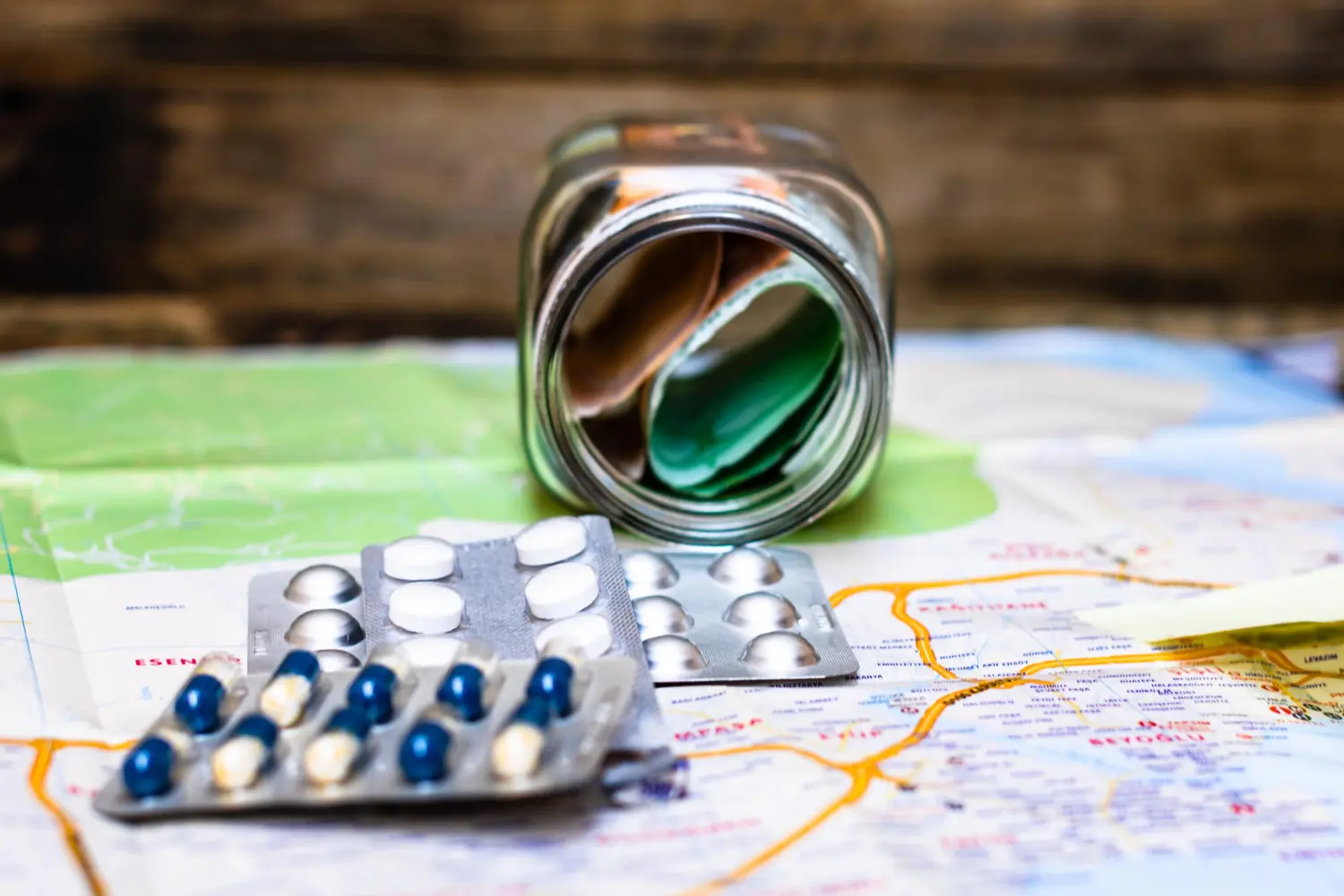 Cartelas de remédios em cima de uma mapa mundial, simbolizando a importação de medicamentos