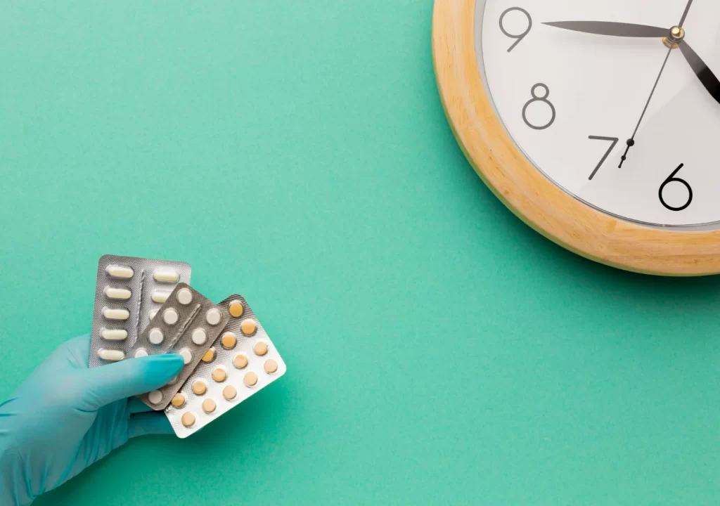 Tempo de prazo de importação de medicamento ilustrado por cartelas de remédios e relógio ao fundo