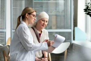 Médica em consulta explica opções de tratamento a paciente oncológico, em ambiente clínico acolhedor e moderno.