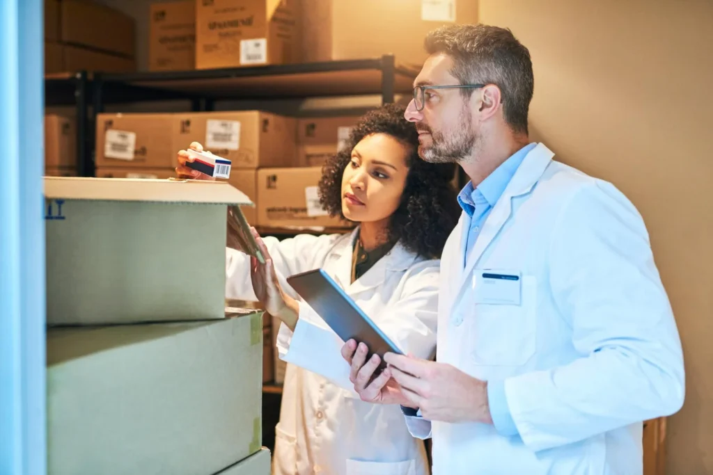Profissionais farmacêuticos conferem estoque para importação de medicamentos.