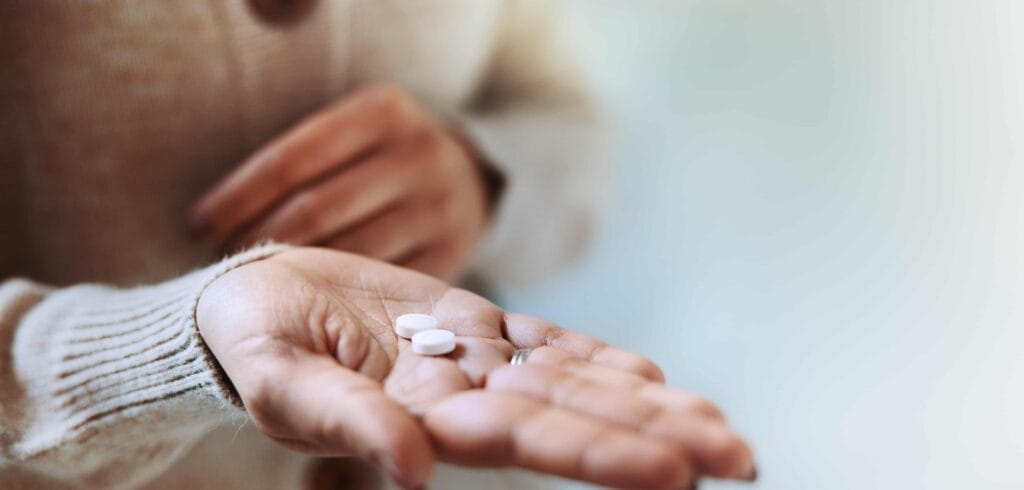 Mulher segura pílulas usadas em hormonioterapia no câncer