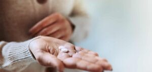 Mulher segura pílulas usadas em hormonioterapia no câncer